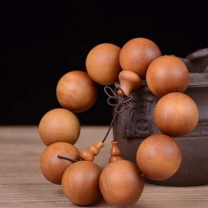 Detail of 25mm sandalwood beads with natural wood grain and decorative Chinese knot