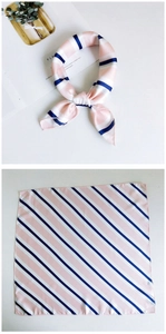 Detail of pink and navy diagonal stripe silk scarf tied in a stylish bow knot