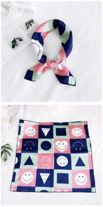 Detail of a square silk neckerchief with colorful geometric patterns and smiley faces