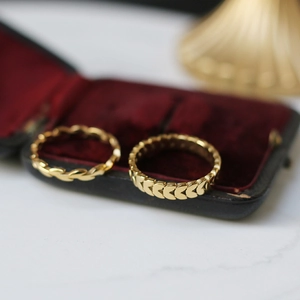Detailed macro view of 18K gold plated wheat ear pattern stacking rings on velvet