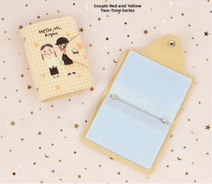Close-up of yellow plaid PU card holder featuring cartoon prints and metal snap button