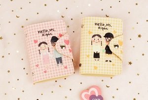 Close-up of pink and yellow PU card holders with couple illustration and metal snap closure