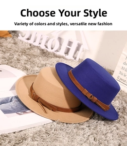 Detail of camel and royal blue flat top wool felt hats with decorative leather buckles
