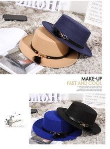 Detail of wool fedora hats with leather belts and fur pompom charms in multiple colors