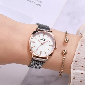 Gros plan sur la montre Tadi en or rose avec cristaux et bracelet tressé assorti