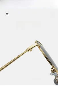 Detailed close-up of golden metal frame sunglasses showing hinge and silicone nose pads