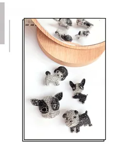 Detail view of 4-piece cute dog brooches with black and white rhinestones set on silver base