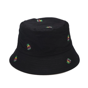 Detailed view of colorful embroidered pineapples on a black cotton canvas bucket hat