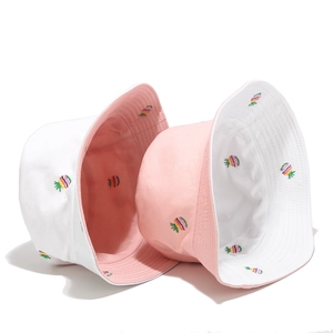 Close-up of reversible bucket hat with colorful pineapple embroidery and cotton texture
