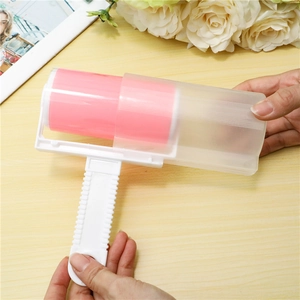 Washable lint roller with pink silicone drum and protective cover on a wooden table
