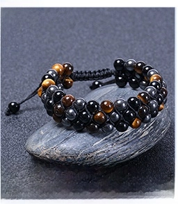 Detailed view of triple-layered tiger eye and hematite stone beads on a woven bracelet