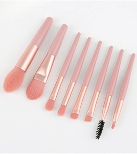Detail of 10 pink makeup brushes with rose gold ferrules on white background