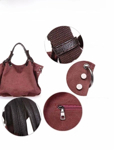 Deep burgundy canvas tote bag detail with leather handles and metallic hardware accents