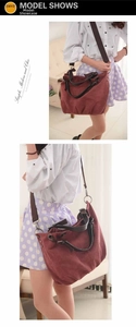 Detail view of burgundy canvas tote bag with adjustable brown strap and metallic rings