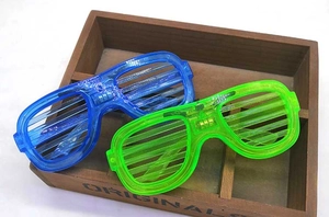 Detail showing blue and green LED shutter glasses with battery pack on a wooden box