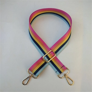Close-up of bohemian colorful striped nylon shoulder strap with gold metal buckle