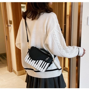Artistic piano-themed crossbody bag with keyboard pattern and silver treble clef detail