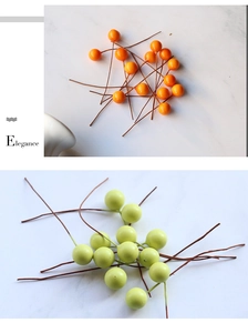 Detail of 10mm artificial berries in orange and light green on marble background
