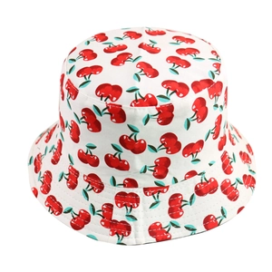 Detailed view of women's white bucket hat featuring a vibrant all-over red cherry print pattern.