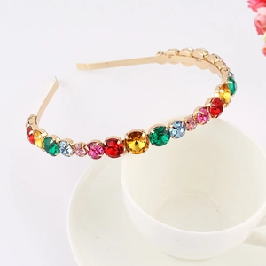 Detailed macro of colorful rhinestones on a gold metal leaf and star headband