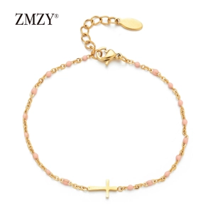 Detail of gold-plated stainless steel cross bracelet with small pink enamel beads