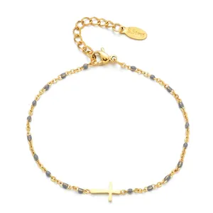 Detail of gold stainless steel bracelet with cross pendant and grey beads and clasp