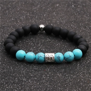 Detail of beaded zodiac bracelet with matte black stone, turquoise, and silver metal charm