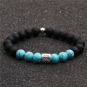 Macro shot of matte black beads and turquoise stone beads with Aquarius zodiac charm