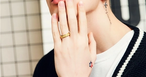 Close-up of gold frosted titanium steel ring worn on model finger with sleek aesthetic