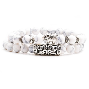 Close-up of white turquoise beaded bracelet featuring a silver elephant pendant and vintage tube