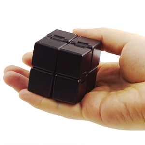 Macro shot of a black infinity cube being folded in palm for stress relief