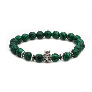 Detail of beaded bracelet featuring green malachite beads and silver lion head with crown