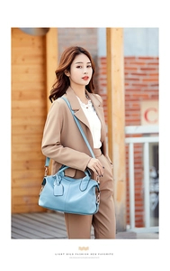 Detail of light blue lychee pattern Boston bag shown on model with shoulder strap