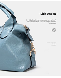 Close-up of light blue litchi grain leather texture and golden metal buckle on handbag