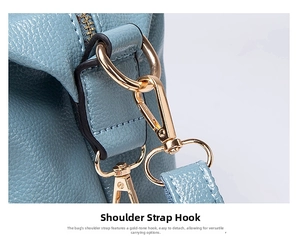 Close-up of golden metal shoulder strap hook and D-ring on light blue lychee leather handbag