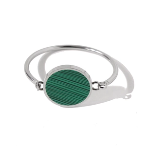 Detail of silver stainless steel bangle featuring a round green malachite stone inlay
