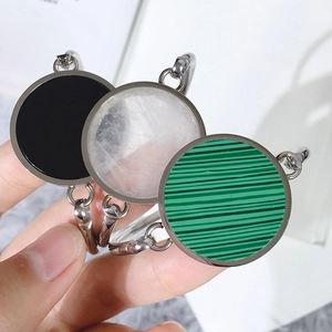 Detailed shot of three silver bracelets with black, white, and green malachite round charms