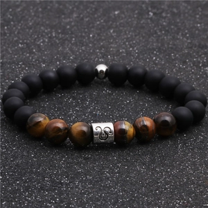 Detail of beaded bracelet with tiger eye stones, matte black beads and Leo zodiac charm
