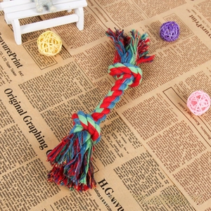 Macro shot of colorful three-strand braided cotton dog rope toy with double knots and tassels