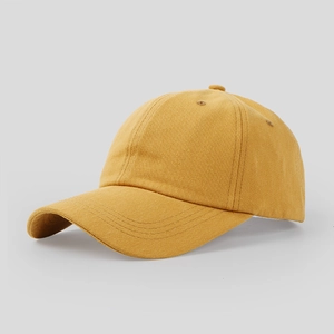 Detailed side view of a mustard yellow cotton baseball cap with embroidered eyelets