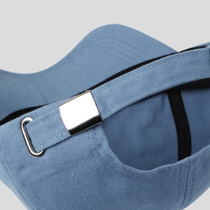 Macro detail of the adjustable silver metal buckle on the blue cotton baseball cap