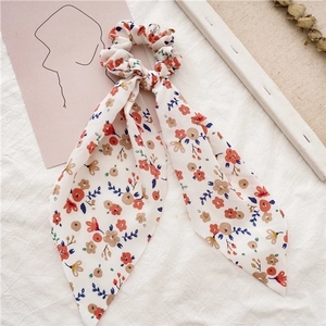 Detail of floral chiffon scrunchie with long ribbons and vibrant meadow flower pattern