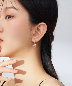 Close-up of model wearing silver butterfly hoop earrings with sparkling zircon crystals