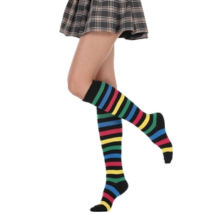 Close-up of colorful striped knee-high socks styled with a dark plaid pleated skirt