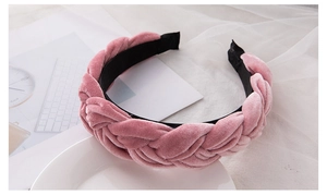 Detail of pink velvet braided headband with soft plush texture on a white tray