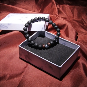 Lava stone bead bracelet for men displayed in a luxury marble pattern gift box