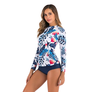 Detailed view of long sleeve rash guard with tropical floral print and navy bottoms