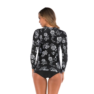 Detail of floral long sleeve rash guard with matching black bikini bottom for surfing