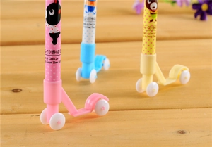 Primo piano di penne a sfera creative a forma di scooter nei colori rosa, blu e giallo