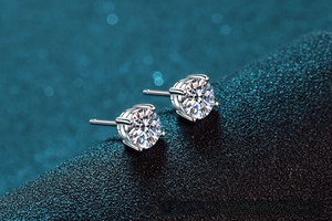 Macro detail of 925 sterling silver four-prong stud earrings with round moissanite stones
